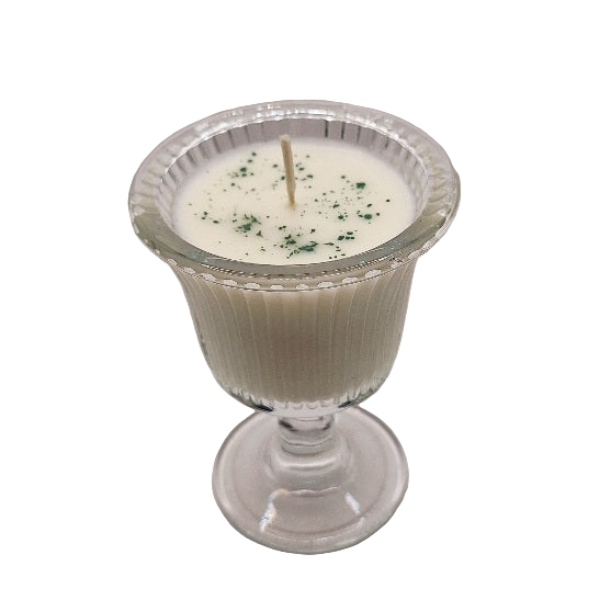 Candle in a glass holder with a textured base on a white background