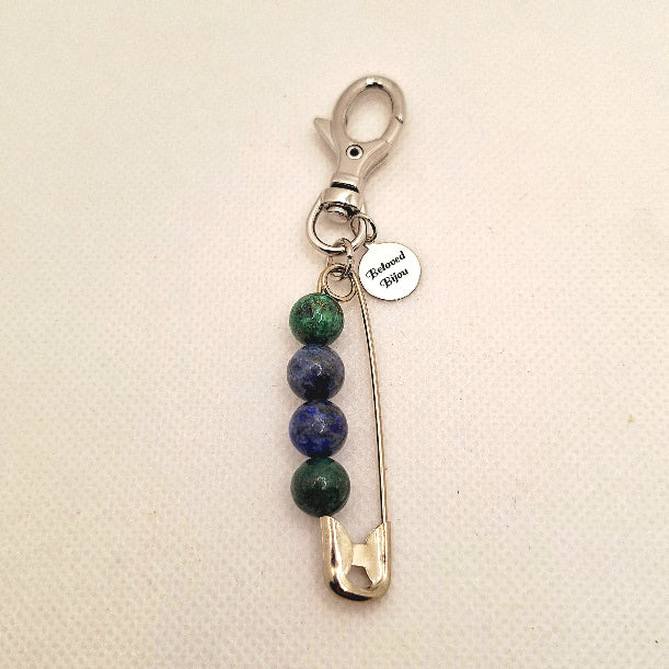 Keychain with safety pin and chrysocolla beads on a beige background
