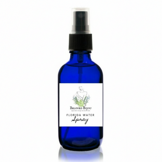 Blue glass bottle with a black spray nozzle labeled 'Florida Water Spray' on a white background