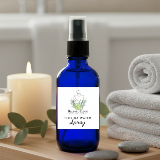 Blue spray bottle with a label on a wooden surface with candles and towels in the background