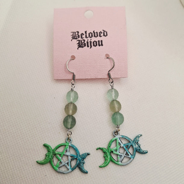 Pair of earrings with green and blue designs on a pink 'Beloved Bijou' card.