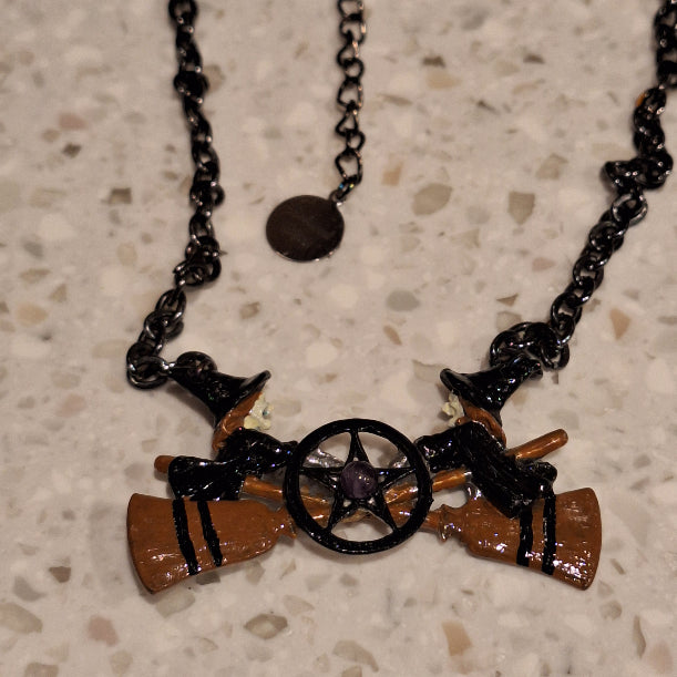 Necklace with cowboy-themed pendants on a textured surface