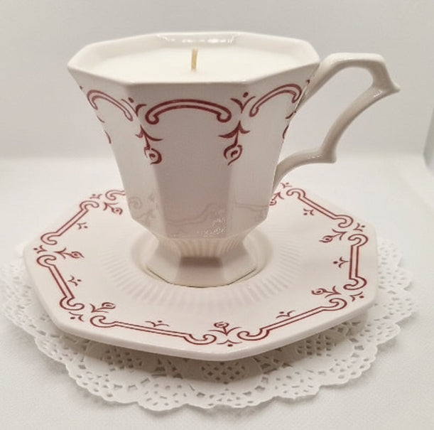 Decorative teacup and saucer with a candle on a white background