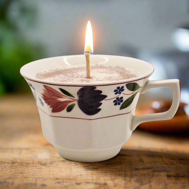 Teacup Candle in a decorative ceramic cup on a wooden surface