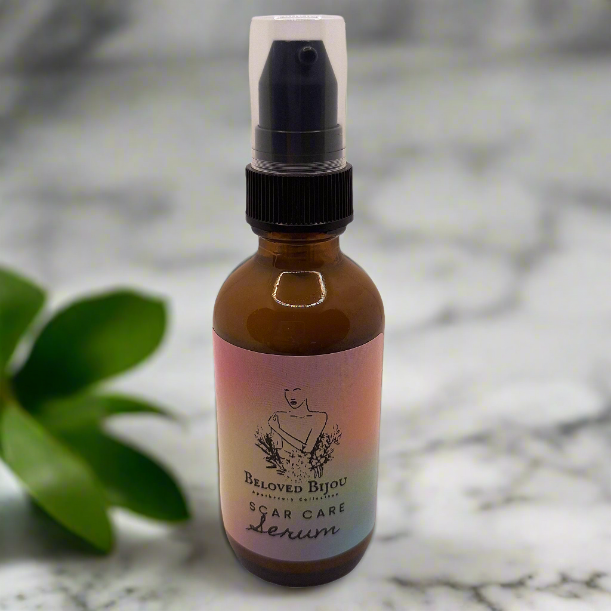 Bottle of Beloved Bijou ear care serum on a marble surface with a blurred background
