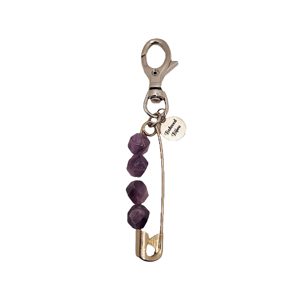 Keychain with purple stones and a safety pin on a white background