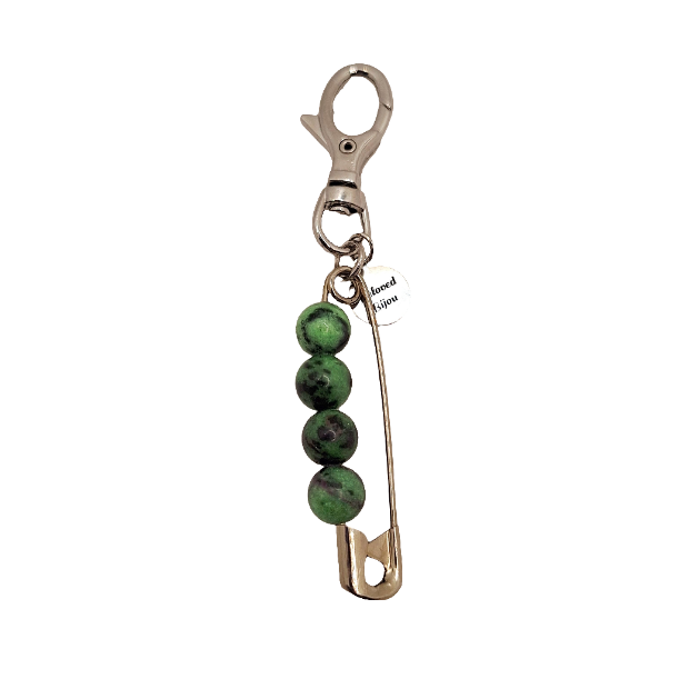 Keychain with green beads and safety pin on a white background