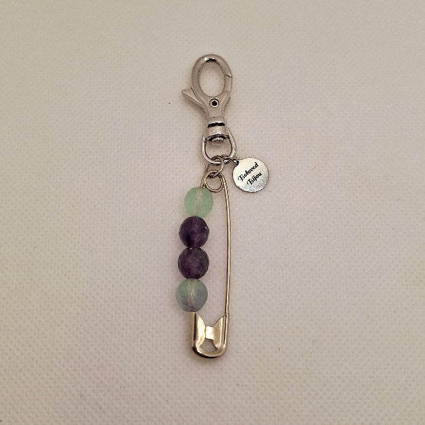 Keychain with safety pin and fluorite beads on a beige background