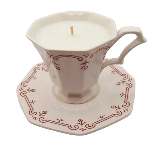 Decorative ceramic cup and saucer with a candle inside on a white background