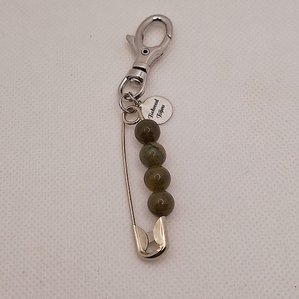Keychain with safety pin and beads on a light gray background