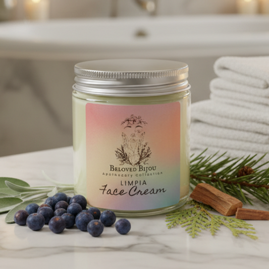 Jar of Beloved Bijou Limpia Face Cream on a marble surface with berries and cinnamon sticks.