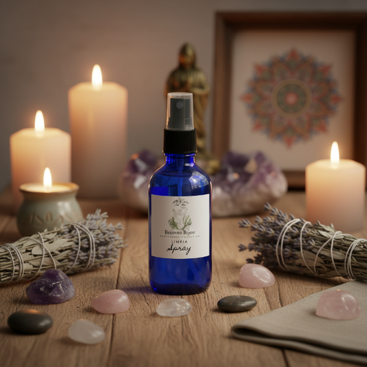 Blue spray bottle labeled 'limpia spray' on a wooden surface with candles, crystals, and smudge sticks.