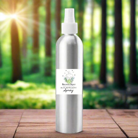 Silver bug spray bottle with a label on a wooden surface in front of a forest background