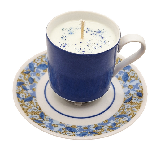 Blue teacup and saucer with a candle inside on a white background
