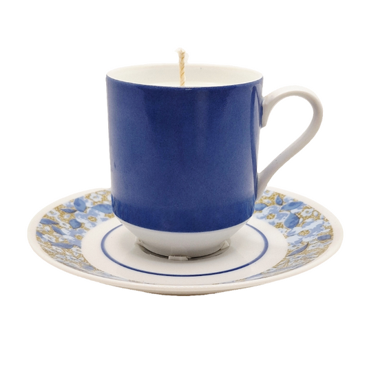 Blue teacup candle on a decorative saucer with floral pattern