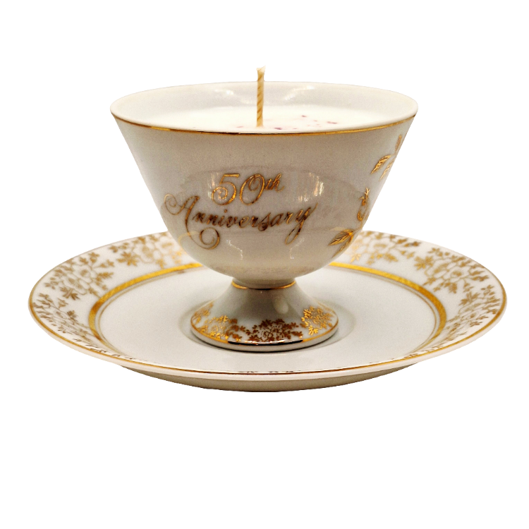 50th Anniversary candle in a decorative porcelain teacup and saucer set on a white background