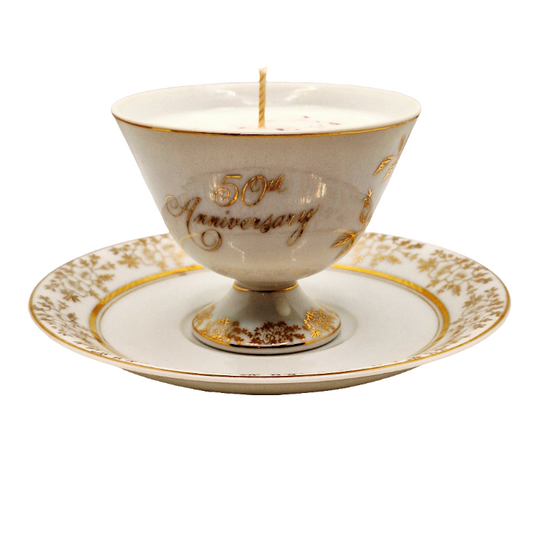50th Anniversary candle in a decorative porcelain teacup and saucer set on a white background