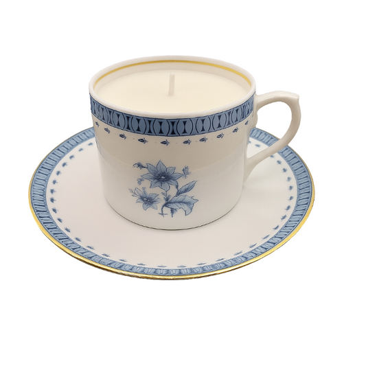 Ceramic cup and saucer with a candle inside on a white background
