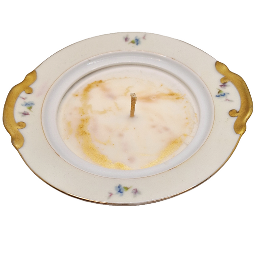 Candle in a decorative lidded dish with floral patterns