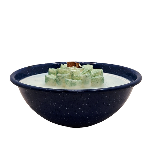 Navy blue bowl with a green wax flower wood wick candle on a white background