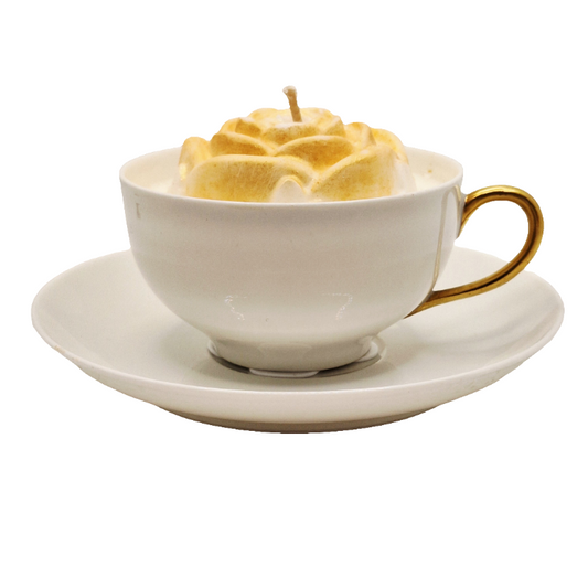 White teacup with gold handle on a saucer, filled with yellow foam