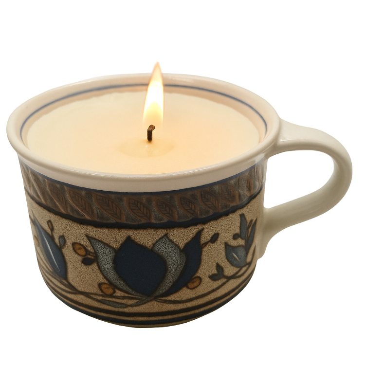 Ceramic mug with a lit candle inside on a white background
