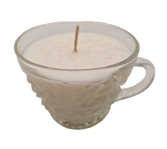 Candle in a glass teacup on a white background