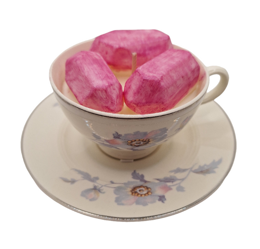 Pink crystal shaped wax in a floral teacup on a matching saucer