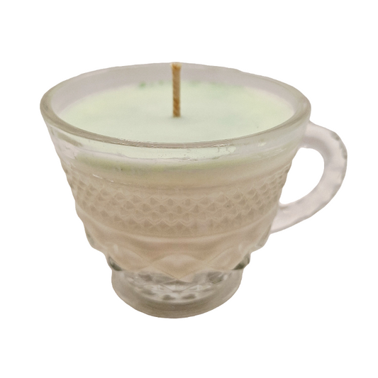 Candle in a glass cup with textured design on a white background